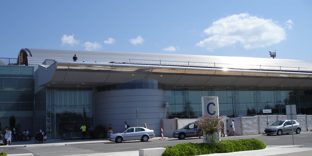 Terminal C of Dubrovnik Airport at Čilipi, with cars parked on the forecourt