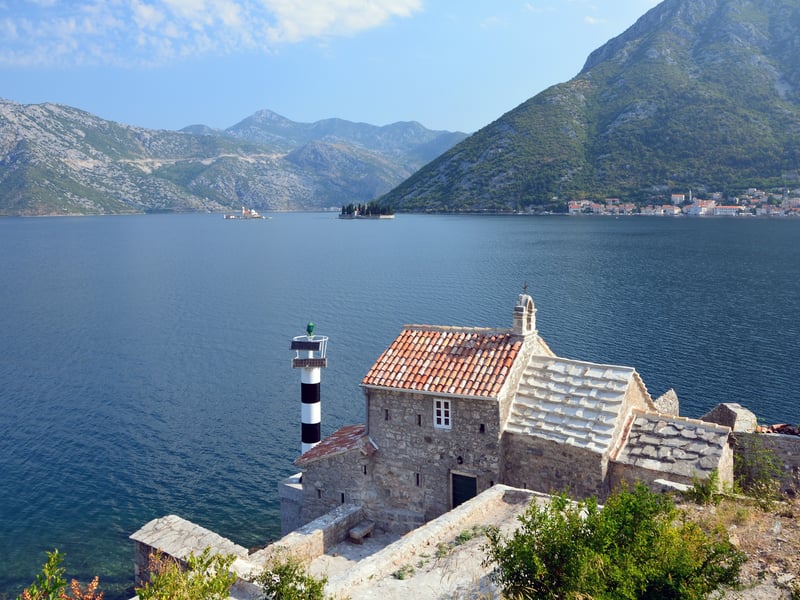The Bay of Kotor and its mountains seen from the road at Lepetane, with a small chapel on the shore