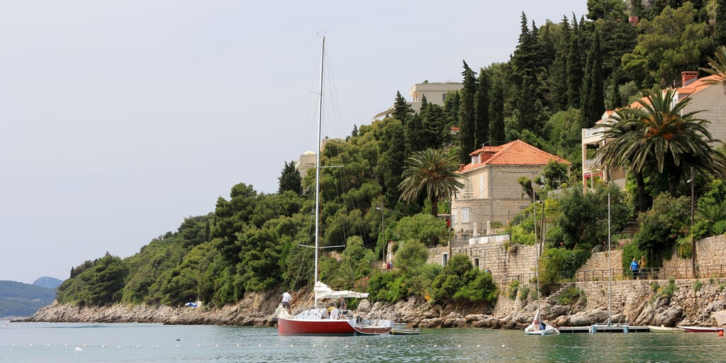 A sailing boat at anchor off the wooded shore of Lapad, Dubrovnik's hotel peninsula