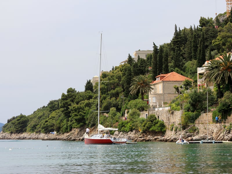 A sailing boat at anchor off the wooded shore of Lapad, Dubrovnik's hotel peninsula